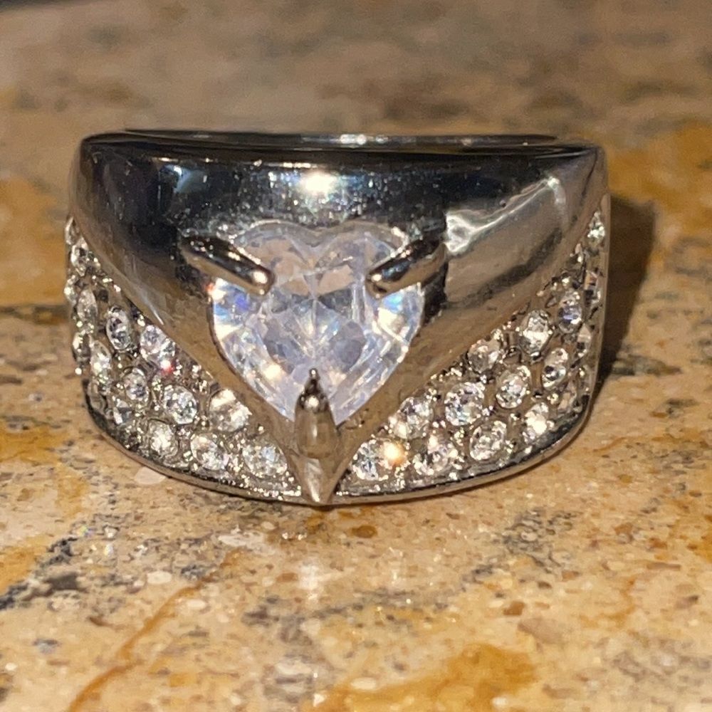 Costume jewelry silver tone ring with heart shaped center clear stone. Size 8
